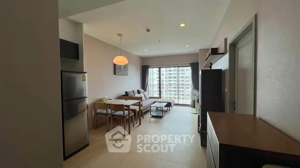 Modern living room with dining area and large window view in a stylish apartment.