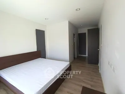 Spacious modern bedroom with wooden flooring and minimalist design
