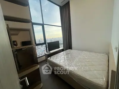 Modern bedroom with large window offering stunning city view