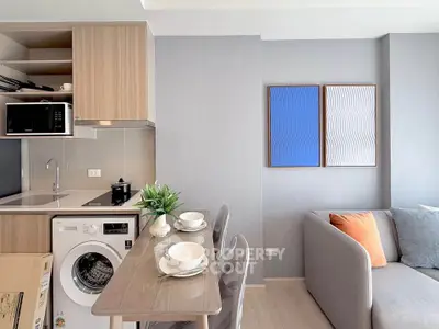 Modern living room with compact kitchen featuring washing machine and stylish decor