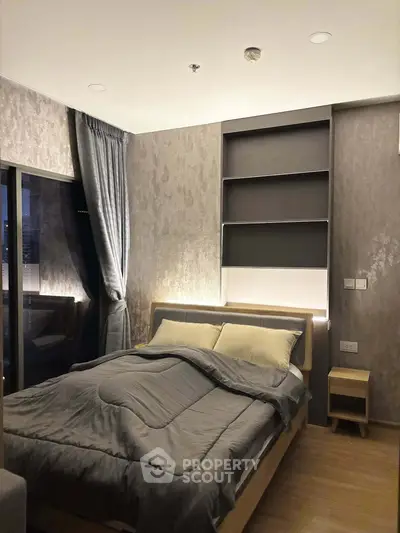 Modern bedroom with elegant decor and cozy lighting in a stylish apartment.