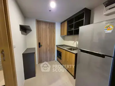 Modern compact kitchen with sleek appliances and wooden cabinetry