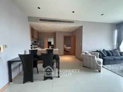 Spacious modern living room with dining area and stylish furniture in open layout apartment.