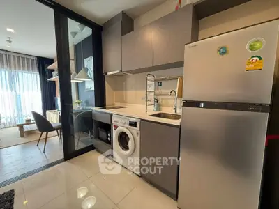 Modern kitchen with washing machine and fridge in stylish apartment