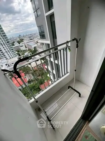 Compact balcony with city view, ideal for urban living, featuring a clothes drying rack.