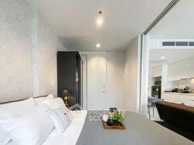 Modern bedroom with stylish decor and sliding door to open kitchen layout