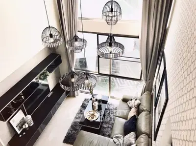 Luxurious high-ceiling living room with modern decor and large windows.
