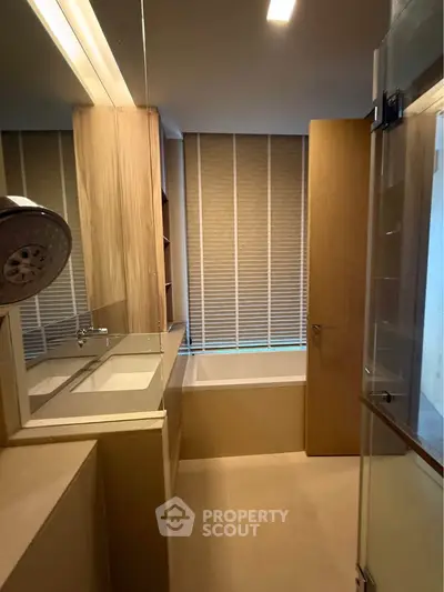 Modern bathroom with sleek design, featuring a bathtub and stylish fixtures.