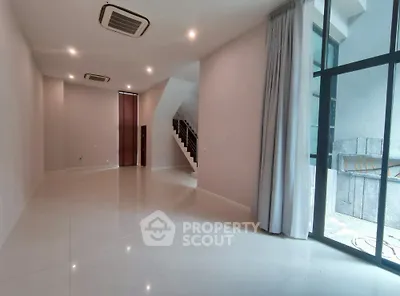 Spacious modern living room with large windows and sleek tile flooring