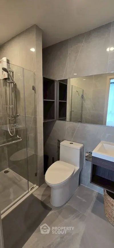 Modern bathroom with sleek design, glass shower, and elegant fixtures in a contemporary apartment.