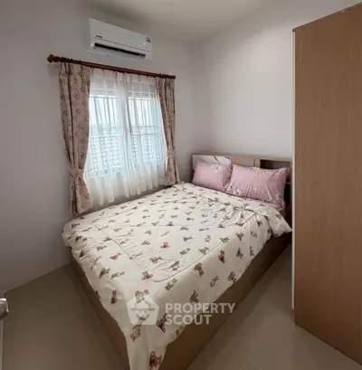 Cozy bedroom with floral bedding and air conditioning, perfect for restful nights.