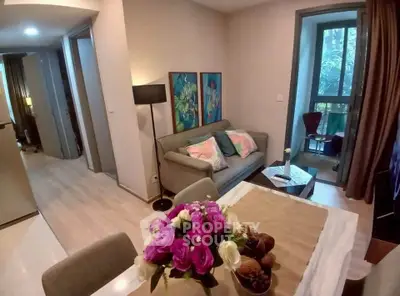 Charming living room with cozy sofa and elegant dining area, featuring large windows and stylish decor.