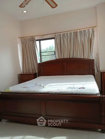 Cozy bedroom with wooden bed frame and natural light through window