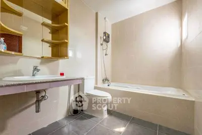 Spacious bathroom with modern fixtures and bathtub in elegant real estate property.