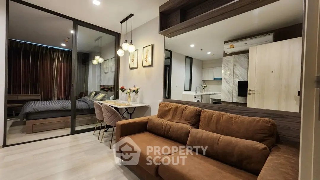 Modern living room with brown sofa and elegant dining area in open layout apartment.