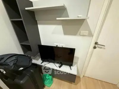 Compact modern living space with TV and storage shelves, ideal for urban living.