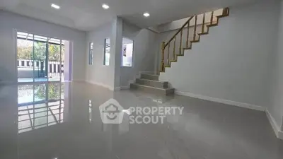 Spacious modern living room with glossy floors and staircase