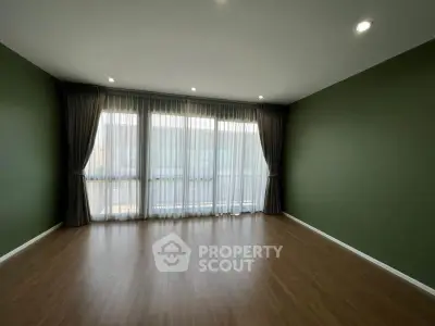 Spacious empty room with elegant floor-to-ceiling curtains and hardwood flooring