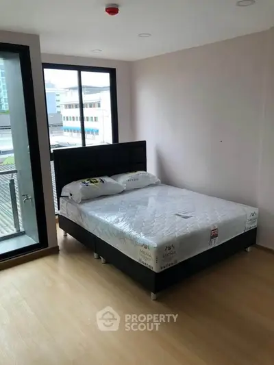 Modern bedroom with large window and minimalistic design in urban apartment