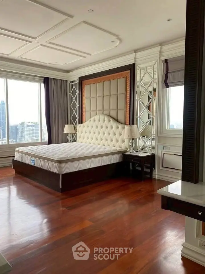 Luxurious bedroom with elegant decor and city view, featuring a plush bed and hardwood floors.