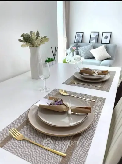 Elegant dining setup with modern decor and cozy living area in the background.