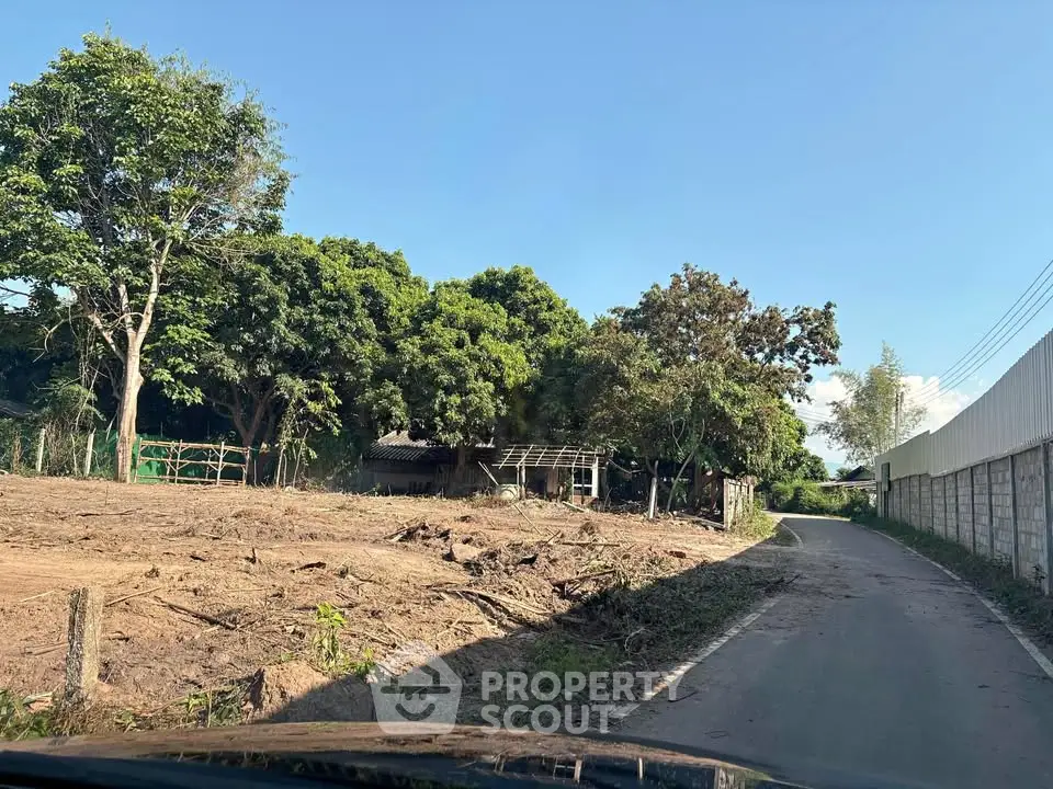 Expansive land plot with lush greenery and clear skies, ideal for development opportunities.