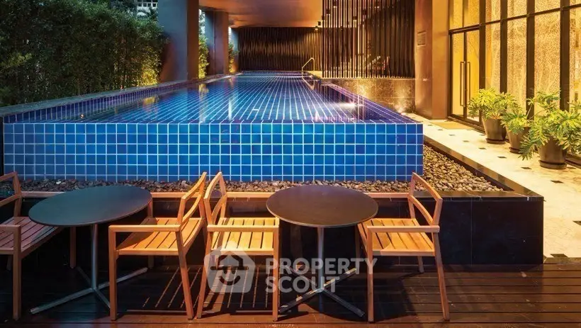 Luxurious modern pool area with stylish seating and ambient lighting in a high-end residential complex.