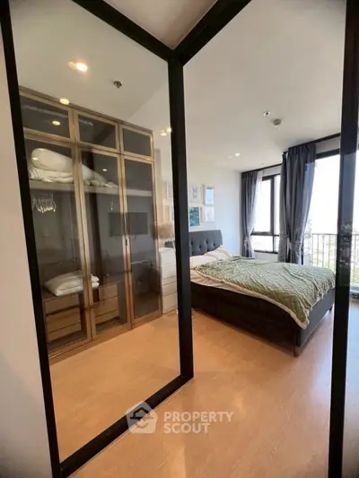 Modern bedroom with glass wardrobe and city view balcony