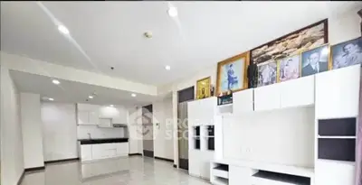 Spacious modern living room with sleek white cabinetry and open kitchen layout.