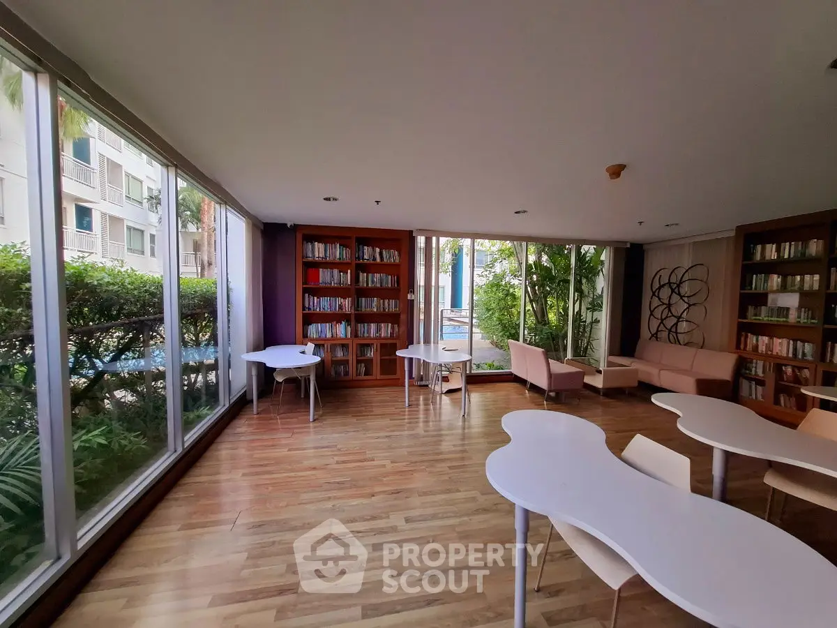 Spacious library with modern design and large windows overlooking greenery.