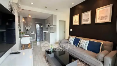 Modern living room with open kitchen, stylish decor, and cozy seating area.