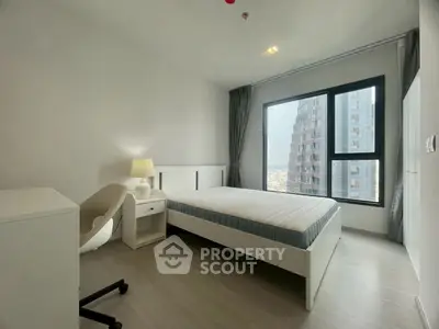 Modern bedroom with large window and city view in high-rise apartment