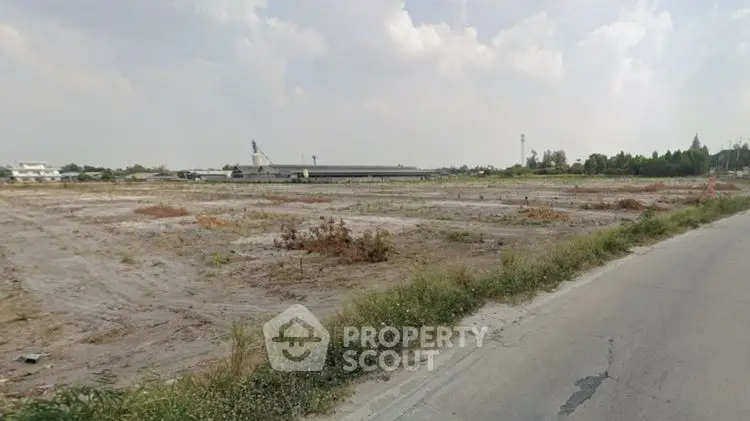 Expansive vacant land with development potential under a cloudy sky