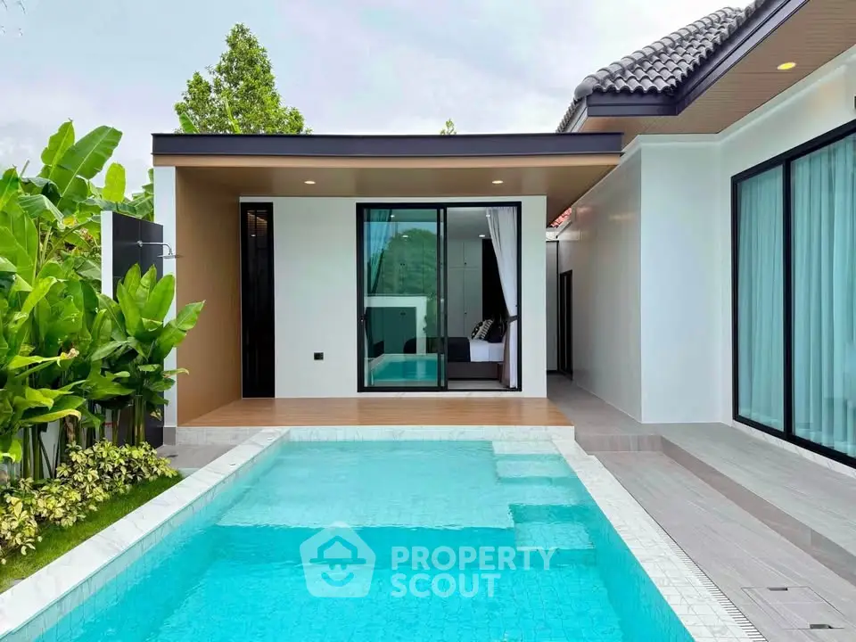 Modern villa with private pool and lush garden, featuring sleek architecture and large glass doors.