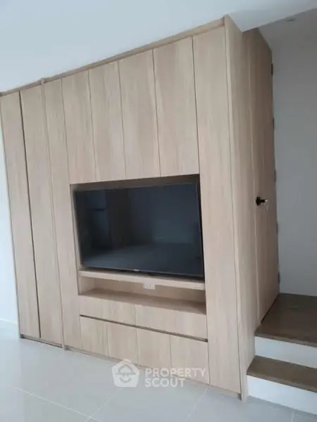 Modern built-in wooden entertainment unit with sleek design and ample storage space.