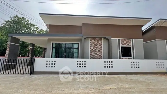 Modern single-story house with stylish facade and gated entrance