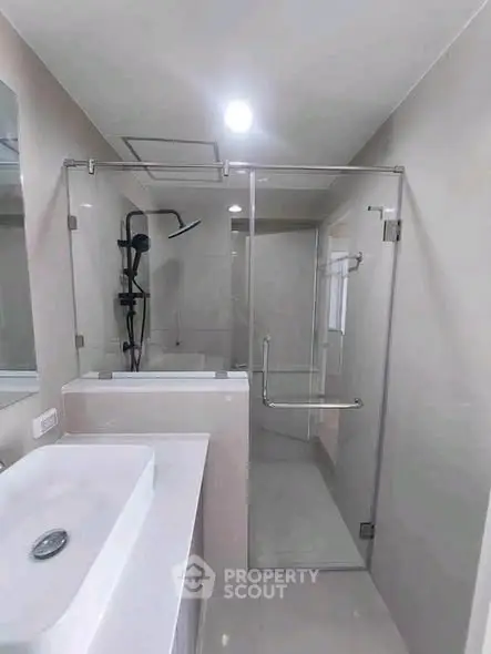 Modern bathroom with glass shower enclosure and sleek fixtures.