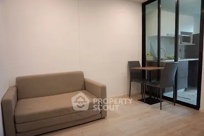 Cozy living room with compact sofa and dining area near modern kitchen