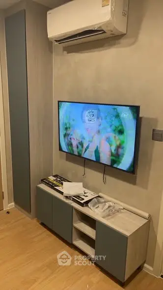 Modern living room with wall-mounted TV and air conditioning unit