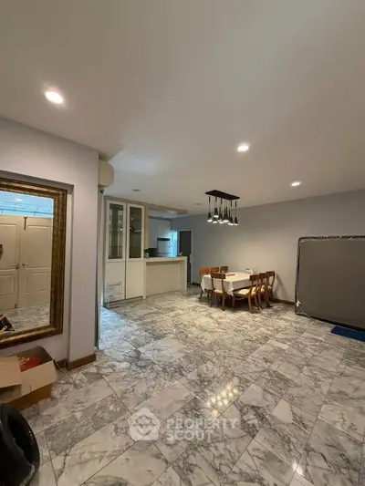 Spacious dining area with marble flooring and modern lighting in open layout home.