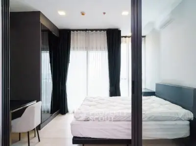 Modern bedroom with sleek design, large windows, and stylish furnishings in a contemporary apartment.