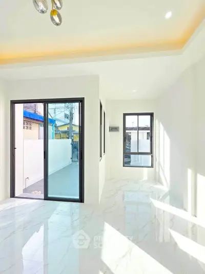 Bright modern living room with marble flooring and large windows for natural light.