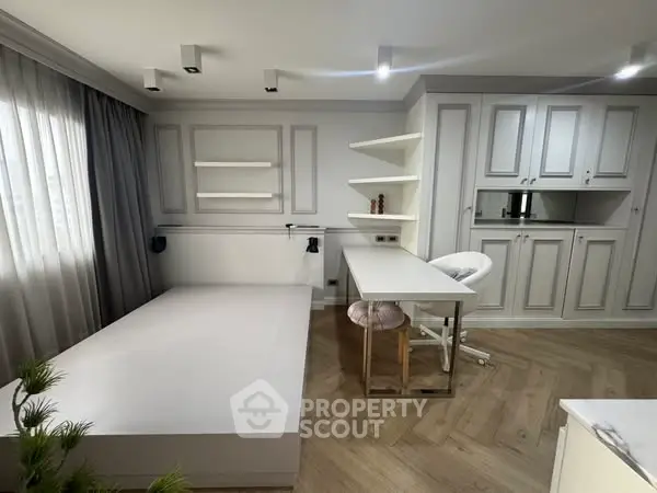 Modern study room with built-in desk and shelves, featuring elegant cabinetry and natural light.