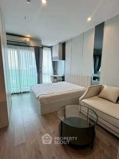 Modern bedroom with stylish decor and large windows offering natural light.