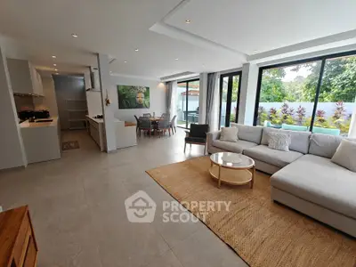 Spacious modern living room with open layout and garden view, perfect for family gatherings.
