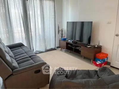 Cozy living room with modern TV setup and comfortable seating.