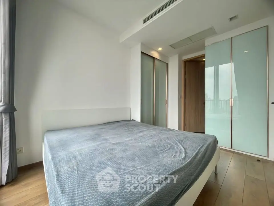 Spacious bedroom with modern design and large windows offering natural light.