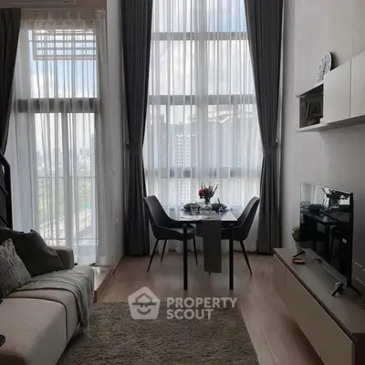 Modern living room with high ceilings, large windows, and stylish decor