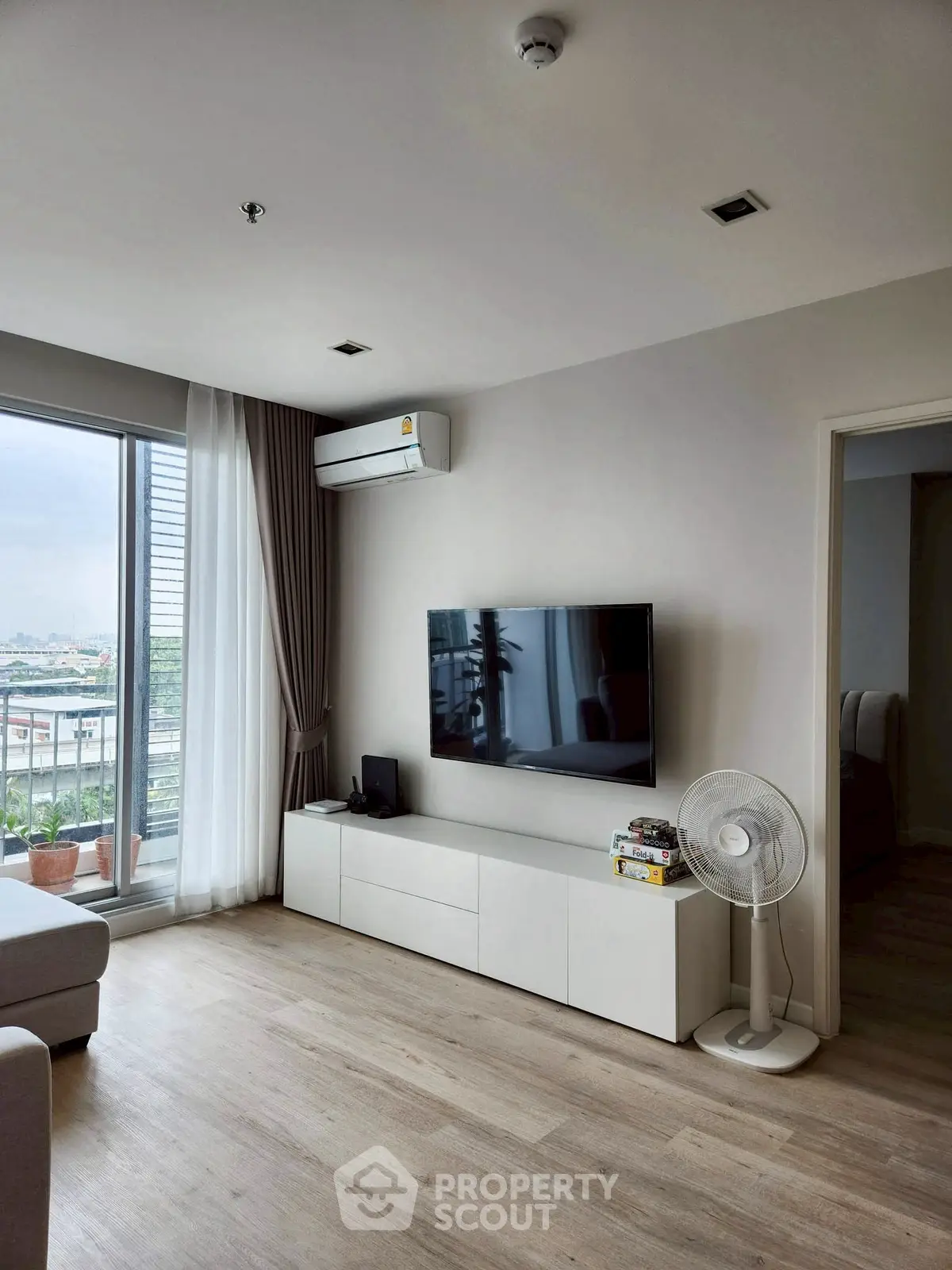 Modern living room with TV, air conditioning, and balcony view