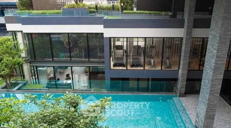 Luxurious modern building with gym and pool view, perfect for upscale living.